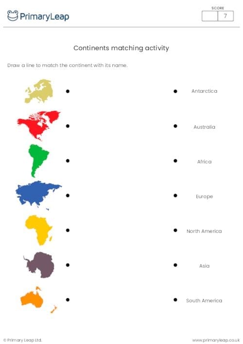 First grade students practicing geography by cutting and pasting labels onto a map of the world