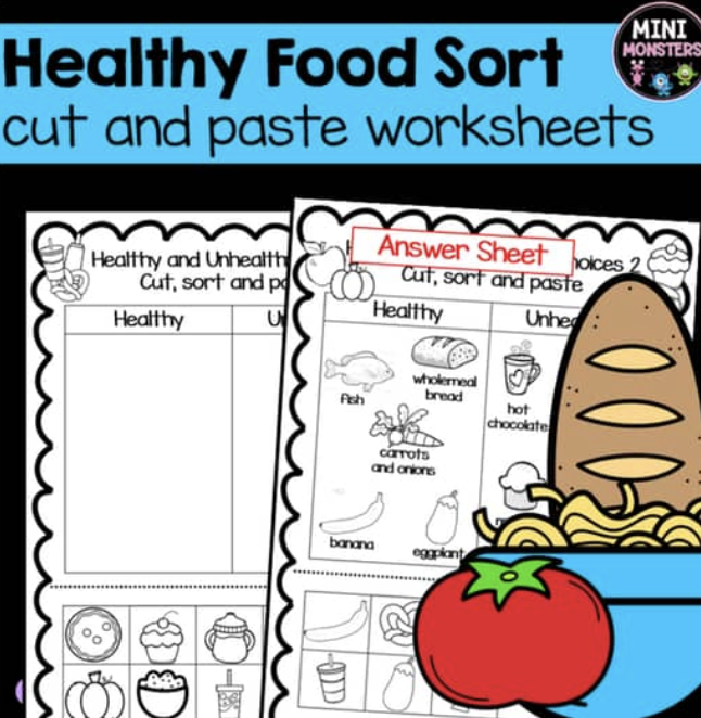 A preschooler practicing motor skills by cutting and pasting paper food items for a healthy lunch project