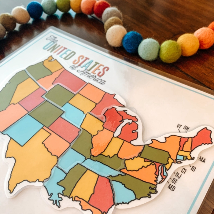 First grade student solving a 50 United States map puzzle worksheet