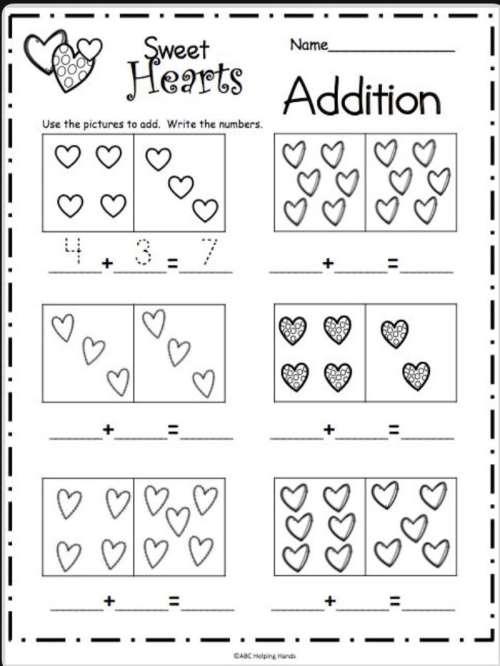 First grade student solving simple addition problems on a festive Valentine math worksheet with kiss illustrations