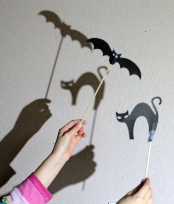 Kindergarten student cutting out a Halloween shadow puppet from a printed activity sheet