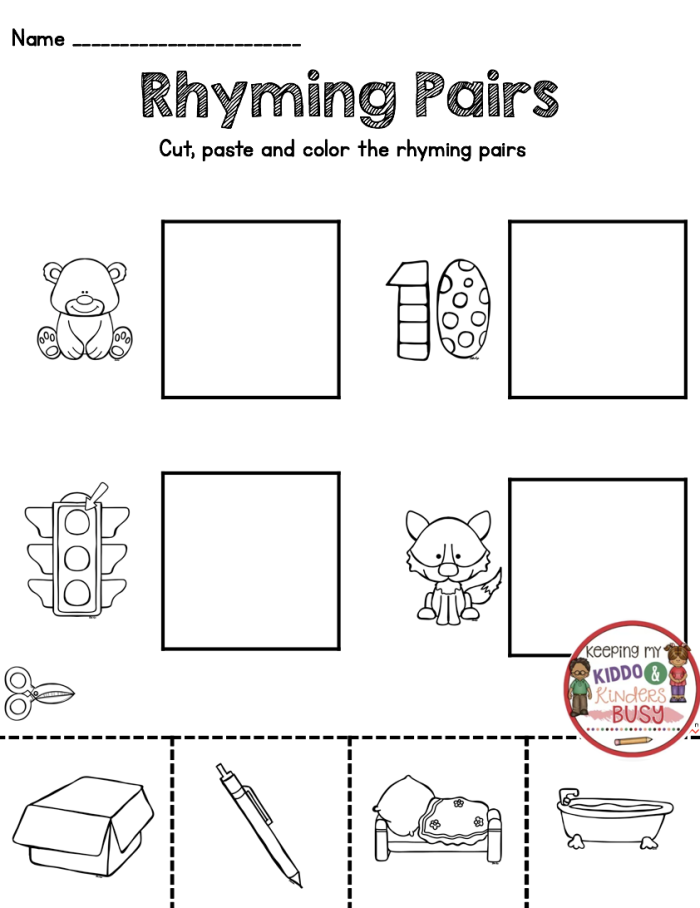 Kindergarten student cutting and pasting rhyming word pairs on a worksheet activity sheet