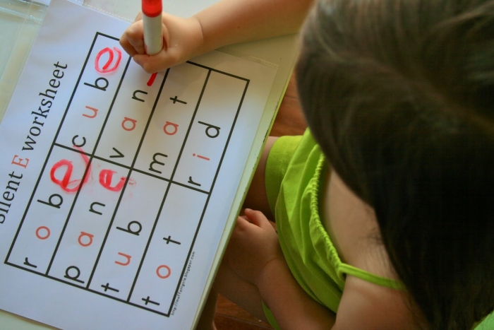 Kindergarten student practicing writing silent e words on an educational worksheet