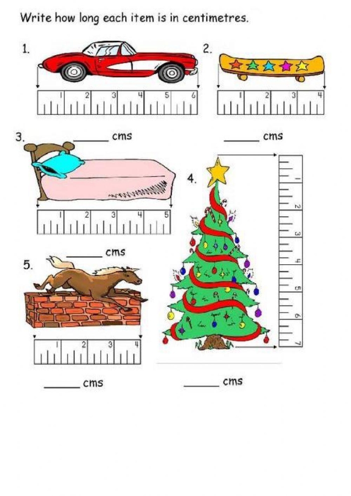 First grade student using a ruler to measure various school supplies in centimeters