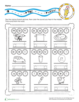 Kindergarten student filling in the blank middle consonant on a phonics worksheet