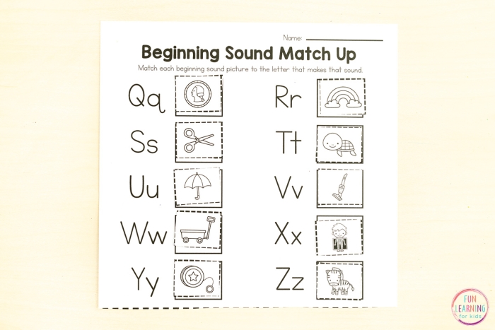 Pre-K student completing a beginning sounds letter match-up worksheet with colorful picture associations