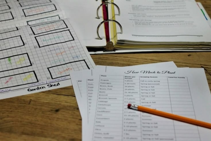 Preschooler coloring and cutting out fruit shapes for a garden geometry activity