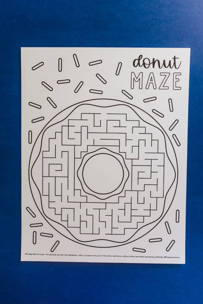 Preschooler tracing a path through the Egg-cellent Maze worksheet puzzle