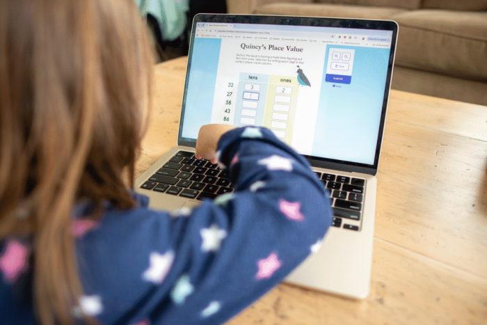 First grade worksheet featuring Quincy's Place Value activity for identifying tens and ones in two-digit numbers