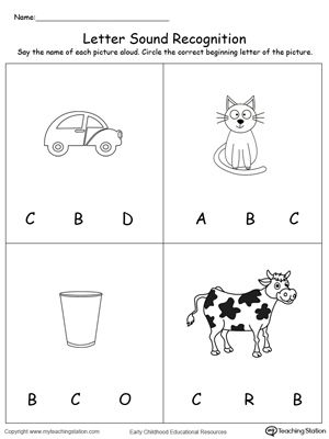 Preschooler identifying items that begin with the letter C on a colorful worksheet